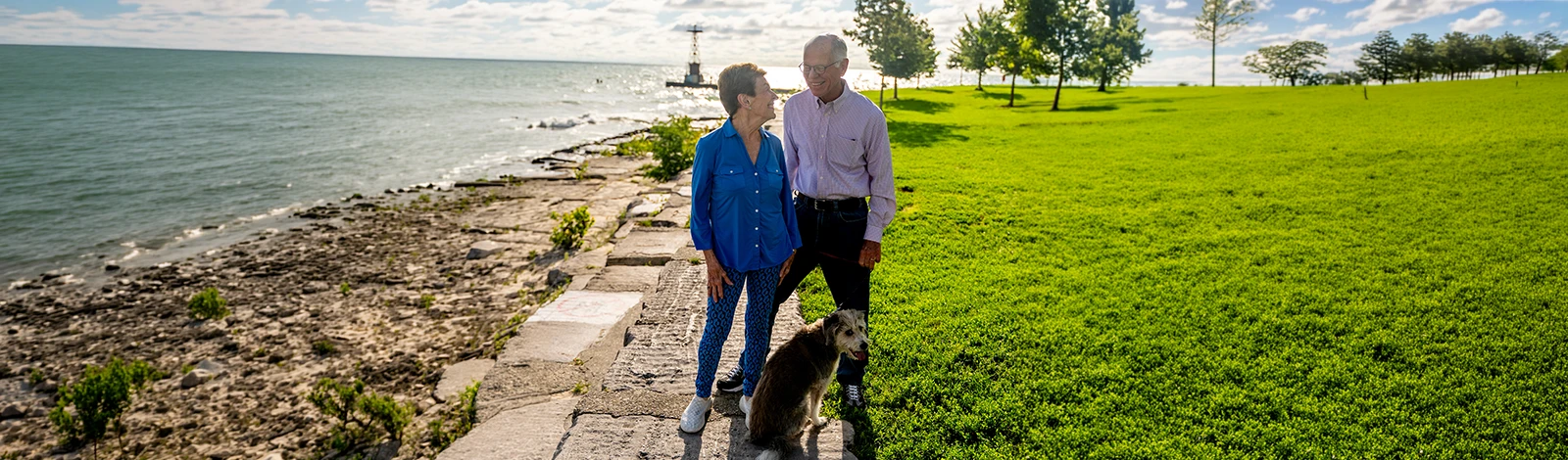 DSC05935-hero Man, woman, and dog on path next to water